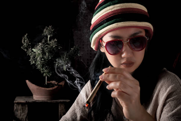 Beautiful Asia women smoking weed at cannabis tree background Beautiful Asia women smoking weed at cannabis tree background blunts stock pictures, royalty-free photos & images