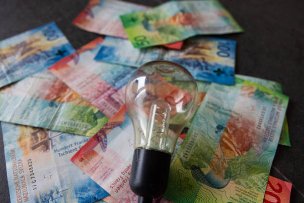 auf vielen schweizer banknoten liegt eine glühbirne als symbol für die energiekrise und den energiesparplan. - swiss currency swiss francs currency swiss coin stock-fotos und bilder
