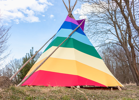 Horizontal landscape photo of a painted teepee in a country field, Taos, New Mexico
