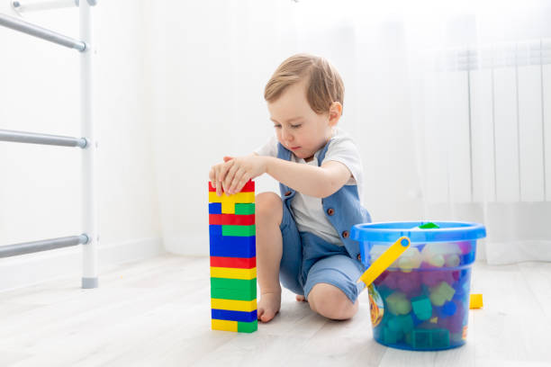 istock a child with a constructor at home, a cute boy plays or collects a colored constructor 1472793217