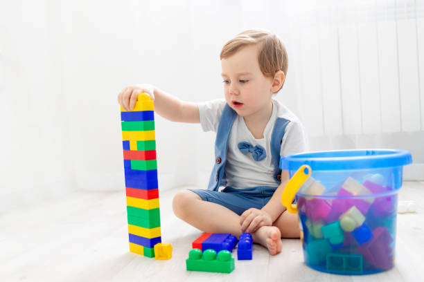 istock a child with a constructor at home, a cute boy plays or collects a colored constructor 1472793244