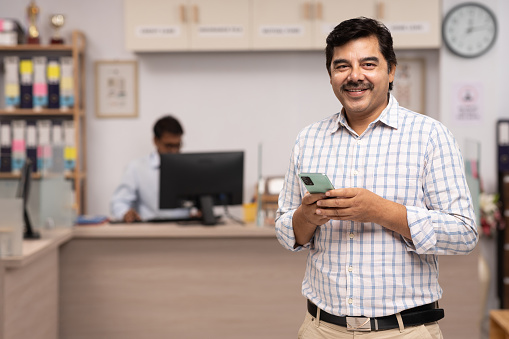 Male customer using a mobile phone in bank