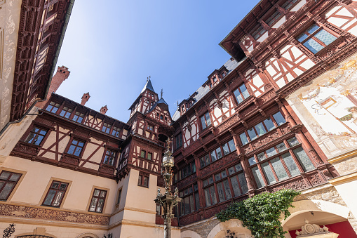 Sinaia - Romania. July 15, 2022: Richly decorated Peles Castle (Castelul Peles) courtyard, Bramantes type, with beauty and richness of the sculpted wood