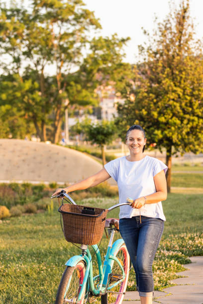 istock Happy smiling woman riding bicycle 1472798715