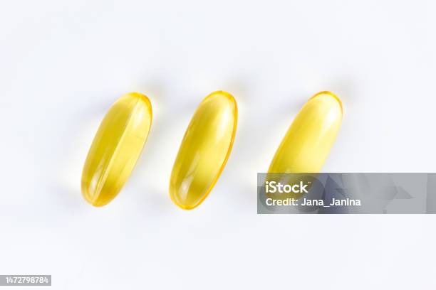 Three Yellow Transparent Capsules With Liquid Omega 3 On A White Background Stock Photo - Download Image Now