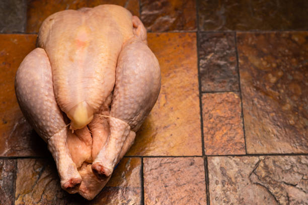 istock Whole whole chicken carcass on stone tile background. 1472800281