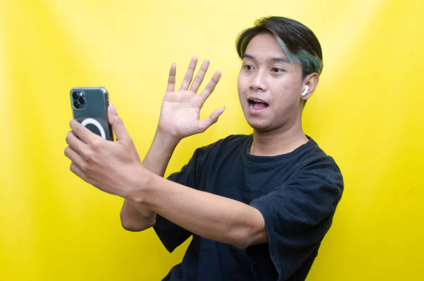 istock Asian man enjoying music using wireless earphone while holding phone 1472804266