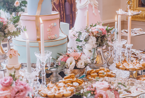 Wedding candy bar, table with sweets decoration setup with delicious cakes and dessert.