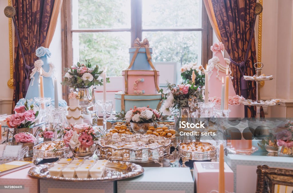 Luxury Cake Table Decorations for Celebrations Elegant sweet table bar ornated variety of French patisserie baking in the banquet hall buffet with a variety of delicious sweets, colorful decorated big cakes, macaroons, fruits, candles, text signs, and pastries for weddings, Valentine's days, birthdays, Christmas, New Year's Eve, or another celebrate events on the table Paris - France Stock Photo