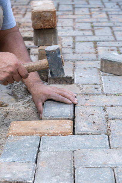 istock Brazilian and construction worker tapping a small mallet on the concrete block_vertical. 1472808463