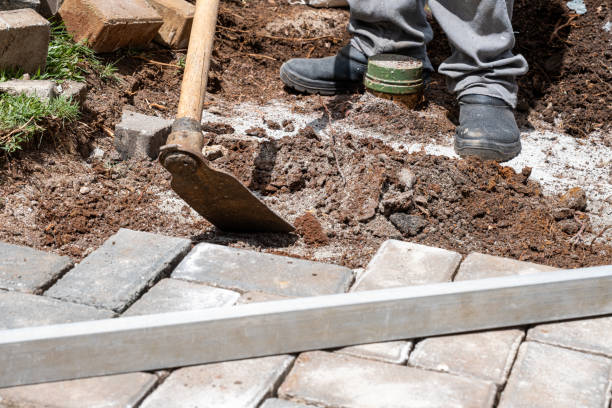 istock Brazilian using a hoe to prepare the soil for laying concrete blocks. 1472808487