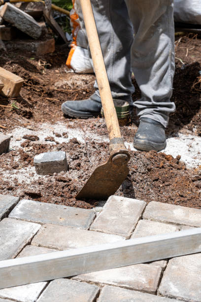 istock Brazilian using a hoe to prepare the soil for laying concrete blocks_vertical. 1472808489