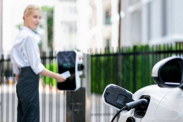 istock Focus progressive EV recharge with blurred woman using credit card in background 1472810721