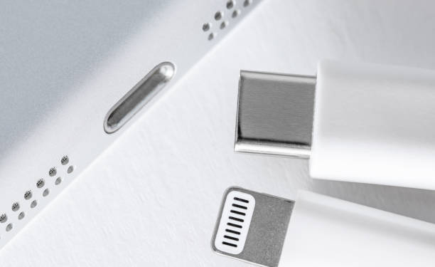 Apple Lightning to USB-C cable on the gradient white background, close up. Technology concept.