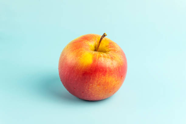 mela rossa matura su uno sfondo blu - apple gala apple fuji apple fruit foto e immagini stock