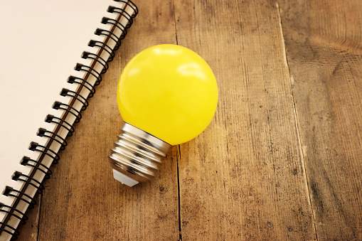 Education concept image. Creative idea and innovation. light bulb metaphor over wooden background