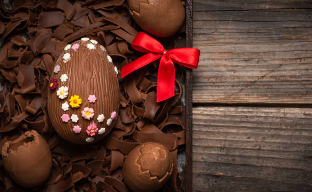 istock Easter decoration. Chocolate egg decorated with small multi-colored flowers 1472817544