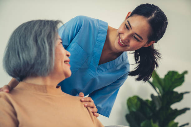 un caregiver appoggia le mani sulle spalle di un paziente anziano soddisfatto. - 5504 foto e immagini stock