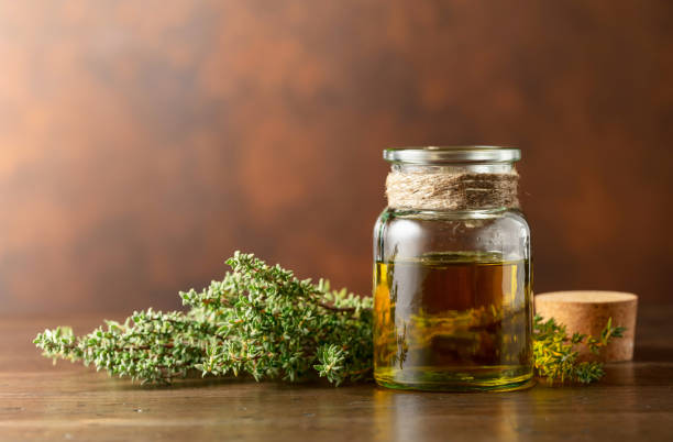 istock Bottle of thyme essential oil with fresh thyme. 1472820766