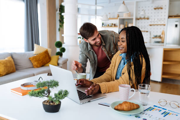 istock Multiracial couple at home, using laptop for home finances 1472823715