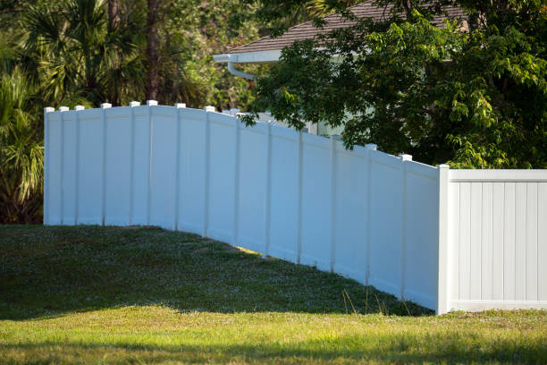 clôture de piquetage en vinyle blanc sur la pelouse verte entourant les terrains de la propriété pour la protection de la cour arrière et l’intimité - garden fence audio photos et images de collection