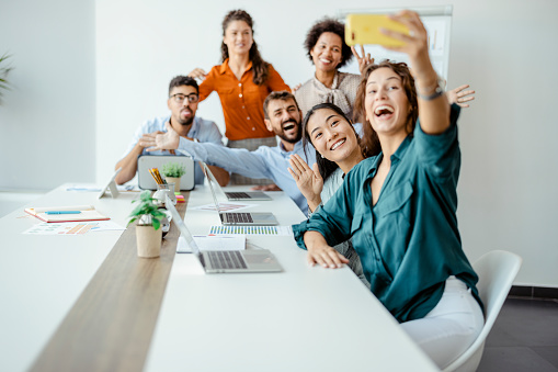 Diverse business team, mixed race employees of different generations taking office selfie