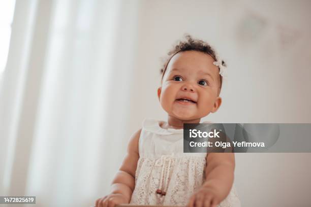 Portrait Of Mixed Race Toddler Girl In Round Wooden Baby Crib At Cozy Childrens Room Neutral Tones Stock Photo - Download Image Now