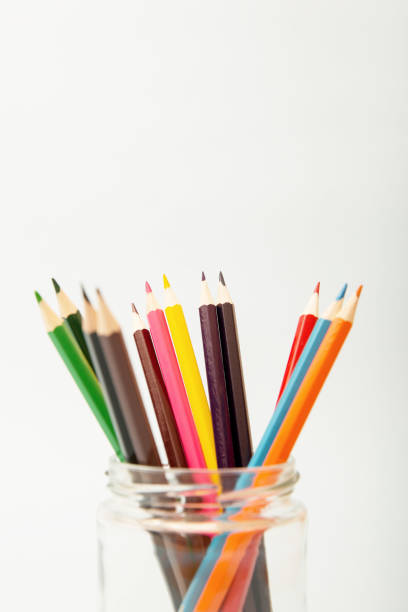 istock Multi-colored pencils in a glass jar on a white background. Copy space, vertical 1472826041