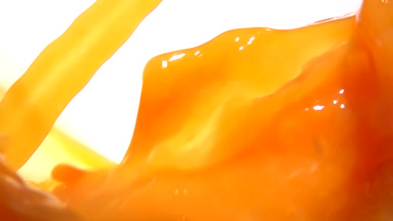 Appetizing orange juice swirling into a wave