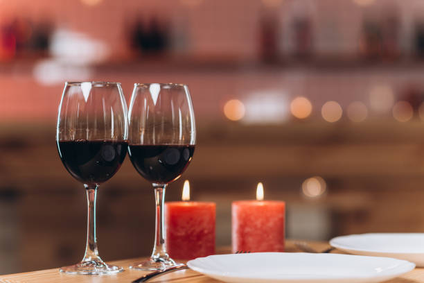 istock Table setting for romantic dinner in restaurant for two person. Wine glasses with red wine at table 1472828174