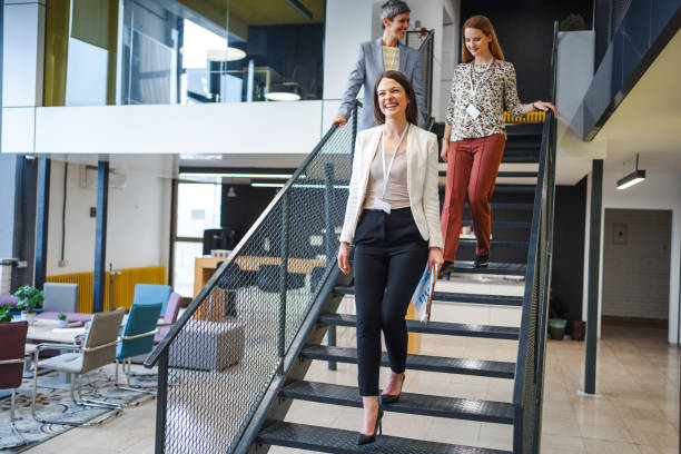 istock Three businesswomen going down the staircase at the office 1472828795