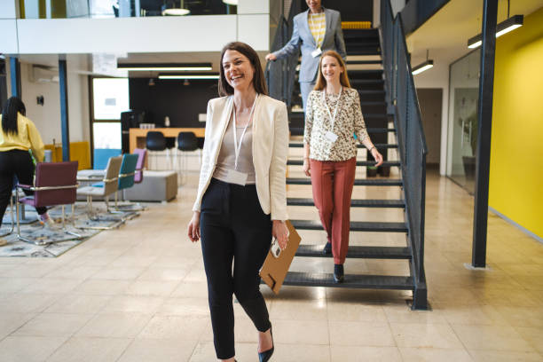 istock Three businesswomen going down the staircase at the office 1472828796