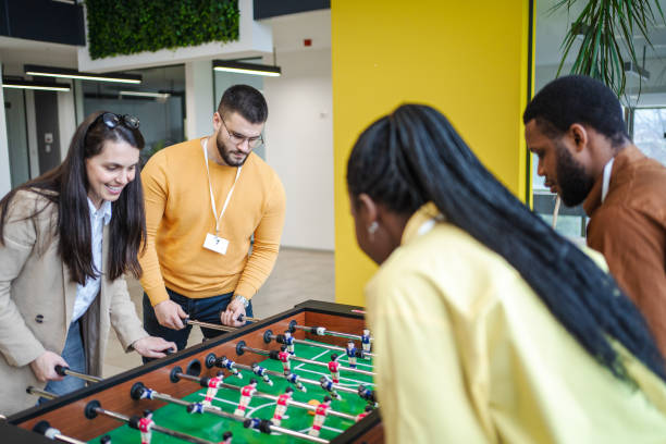 istock Group of multiracial colleagues having fun while playing Foosball 1472828824