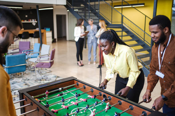 istock Group of multiracial business colleagues having fun while playing Foosball 1472828835