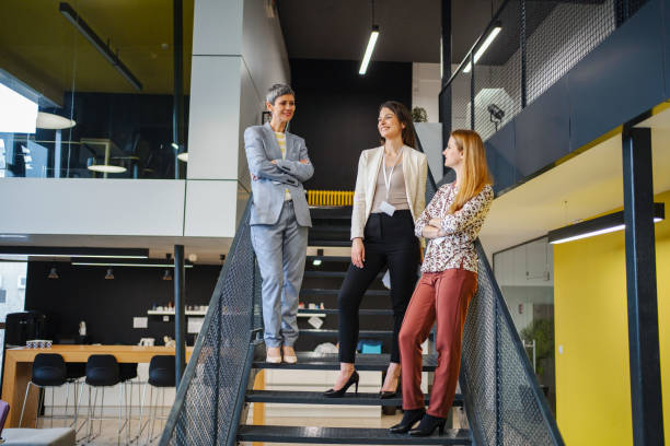 istock Three businesswomen chatting on staircase 1472828879