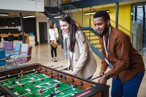istock Two multiracial business colleagues having fun while playing foosball on a break from work 1472828895