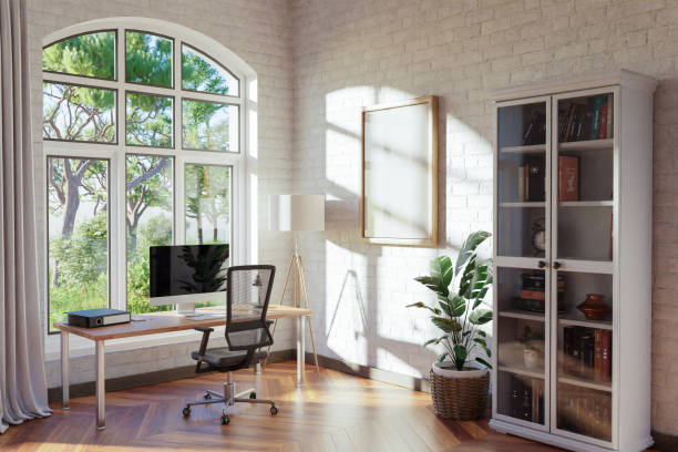 istock comfortable workplace with pc standing on wooden desk in office at home; bright sunlight shines from side through large window; wall with canvas copy space;  remote work freelance concept; 3D Illustration 1472828975