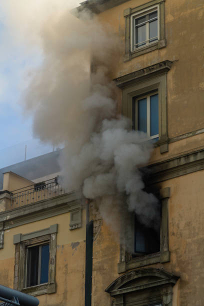 Domestic apartment fire with smoke billowing from window. Garibaldi Square, Naples, Italy - fotografia de stock