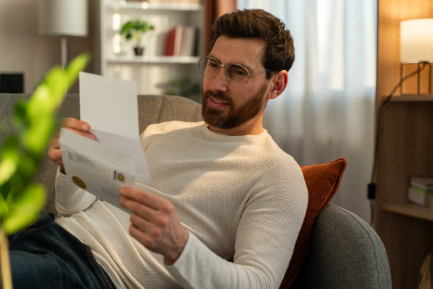 istock . Focused businessman working with correspondence while laying at the couch at home 1472829560