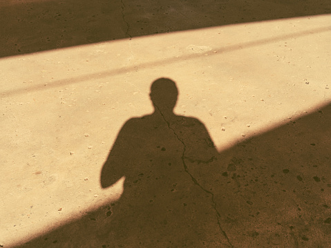 a shadow of three people standing in front of a white wall
