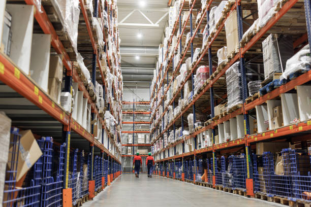 istock Two workers walking along the shelves in a warehouse. 1472835306
