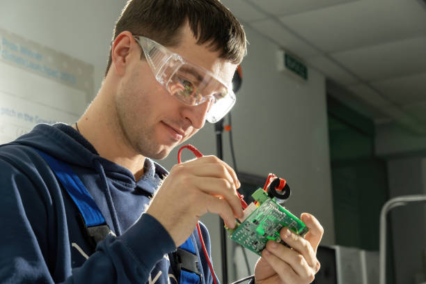 istock Man technician works with motherboard soldering cables 1472835483
