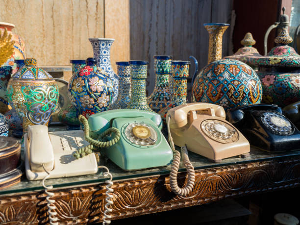 Collection of random old items including analog telephone receivers for sale at an antique store
