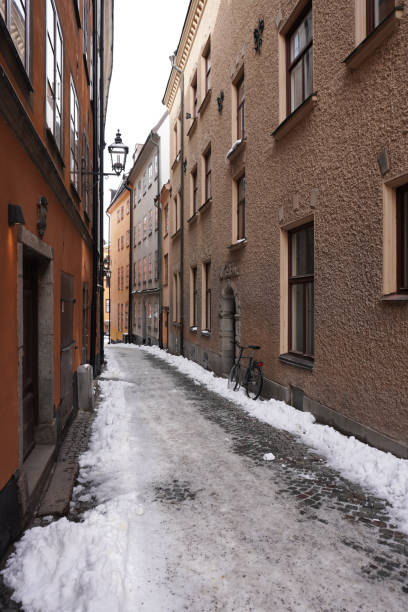 istock Empty alley amidst buildings in city during winter 1472838456