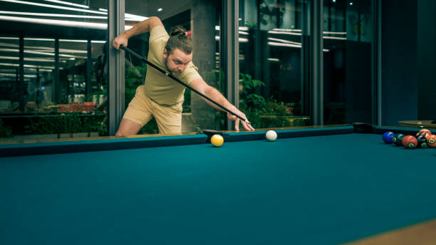 istock Concentrated, bearded man playing billiard in a pool hall. 1472839679