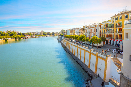 The vibrant colors of the Triana District alongside the Guadalquivir river in the historic Andalusian city of Seville, Spain.