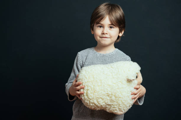 istock Little boy hugs his plush toy lamb 1472847139