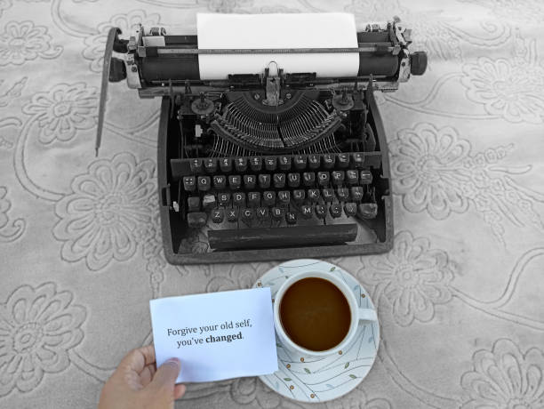 Note on a paper with old typewriter on background - Forgive your old self, you have changed.