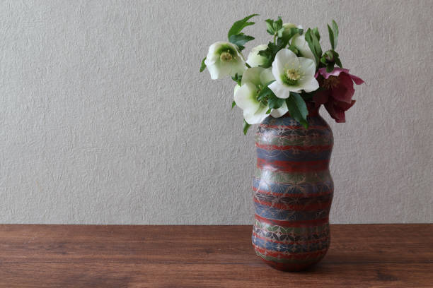 istock Christmas rose in a vase on a wooden table with copy space. 1472848323