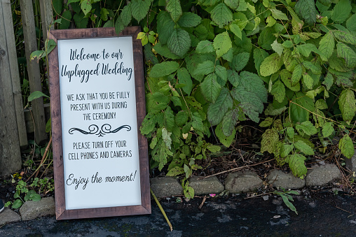 A rustic welcome to our unplugged wedding sign placed by the bride and groom to the entrance of their wedding ceremony.